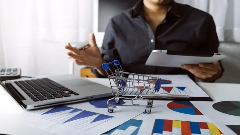 Homem analisando gráficos com carrinho de compras
